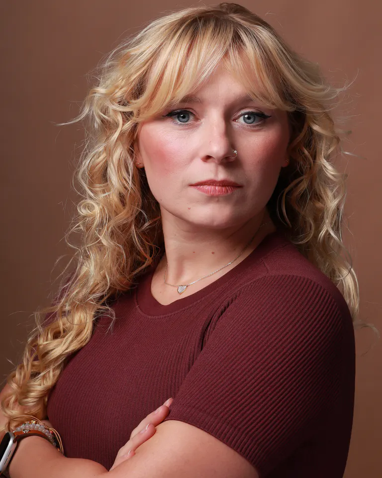 Actor headshot in a burgundy top against a warm brown background at HQ Portraits in Charlotte