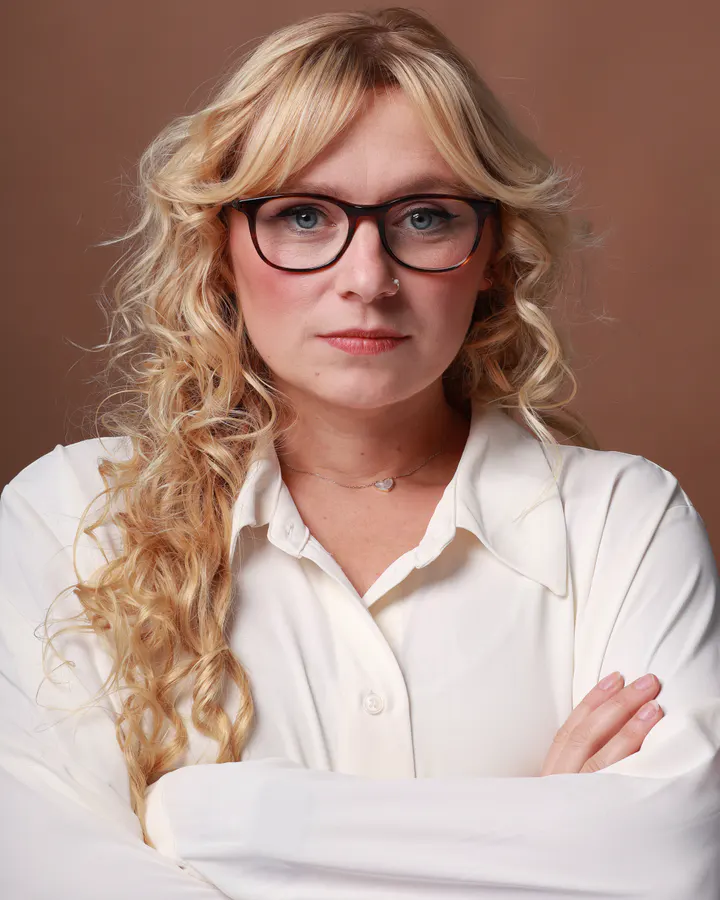 Doctor or therapist casting direction with a white blouse, glasses, and direct expression